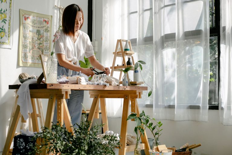 Créatrice artisane fabriquant ses produits faits main dans son atelier lumineux