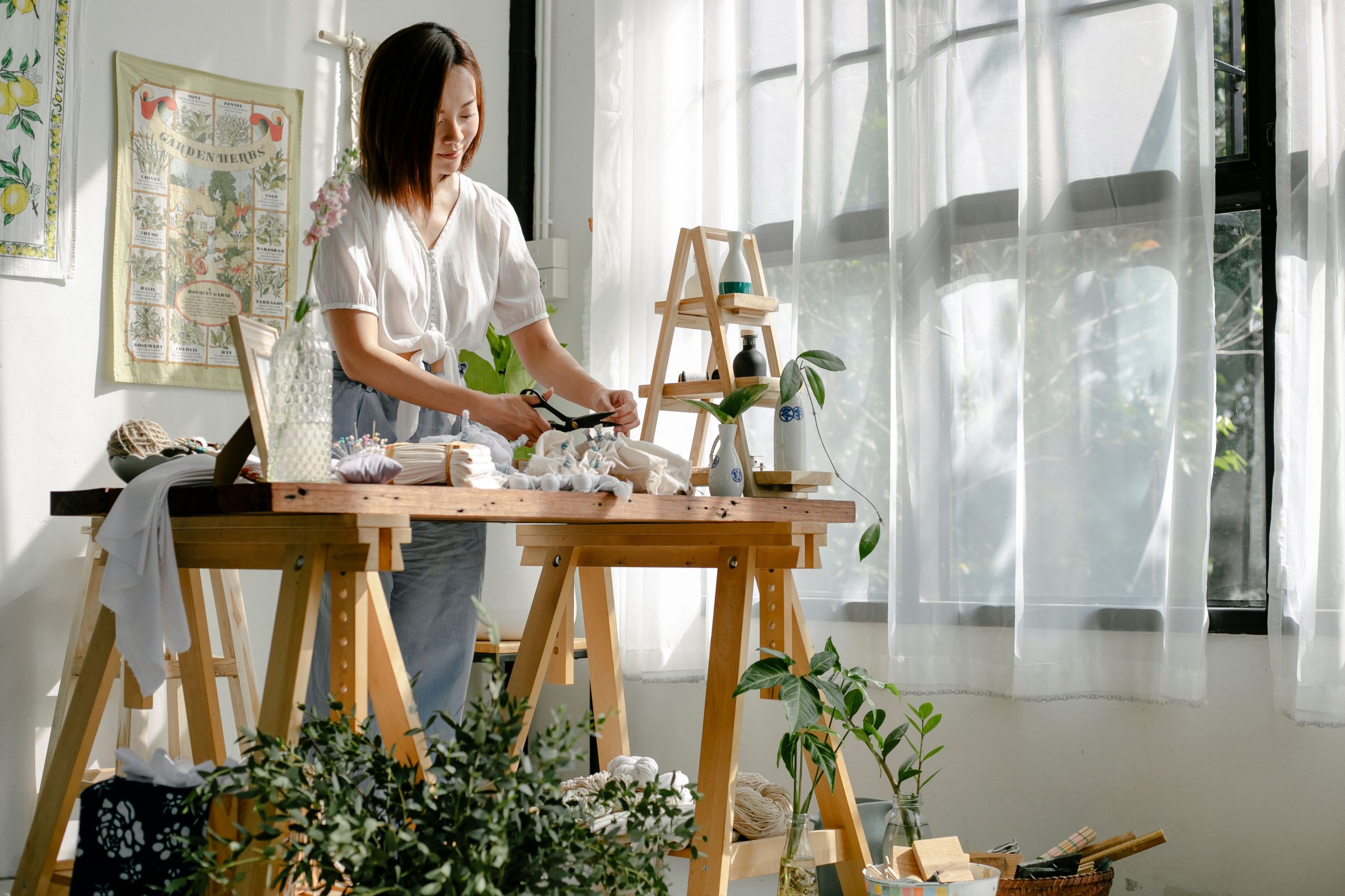 Créatrice artisane fabriquant ses produits faits main dans son atelier lumineux